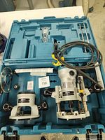 Router set in carrying case showing router motor, plunge base, fixed base, accessories