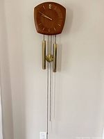 Full view of wall clock with weights, pendulum and chains