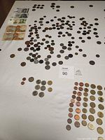 Overall view of scattered world coins and banknotes laid out on table