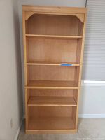Front view showing full height bookcase, shelves, arched top detail