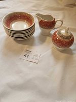 All eight pieces grouped: six bowls stacked, creamer, lidded sugar bowl