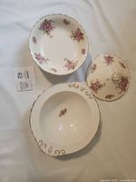 Serving bowl, butter dish lid, additional bowl with floral motif visible
