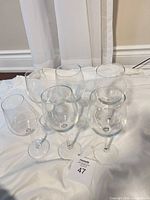 Six clear stemmed wine glasses on cloth