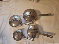 Four saucepans with lids, top view