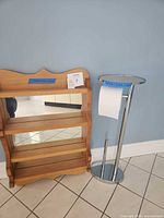 Overall view of wood shelf with mirror and chrome toilet paper holder