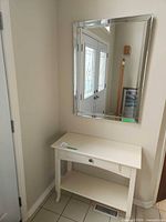 Console table beneath wall mirror in entryway