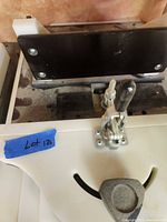 Close-up of white plastic jig with metal toggle clamp
