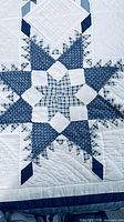 Close-up of blue star quilt block detailing fabrics and stitching