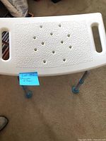 Top view showing textured plastic seat with drainage holes and integrated handles