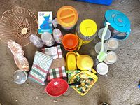 Full layout of assorted kitchenware, linens, and candles on carpet