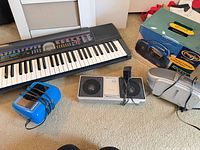 Overall view showing keyboard, boombox components, Freeplay radio and box, AC adapter, cables