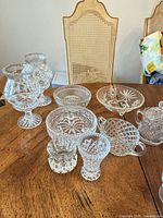Full set of clear crystal and pressed glass pieces on table