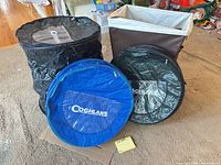 Four Coghlan's pop-up hampers: one black open, one brown rectangular open, one blue folded, one black folded