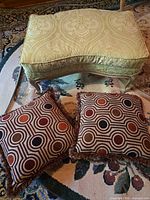 Ottoman top and front view with two pillows displayed on rug