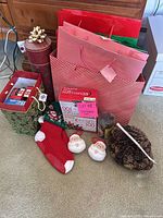 Group of holiday items including lights, stocking, ornaments, gift bags