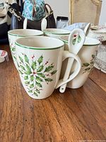 Front view of four Lenox holly/berries mugs with spoons