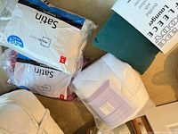 Bagged satin pillows, green fleece lounger, white mattress topper