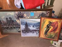 three framed prints leaning together showing subjects and frames