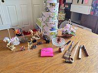 Overview of all items on tabletop including carousel horse, figurines, perfume bottles, hat boxes, letter openers and glass dish