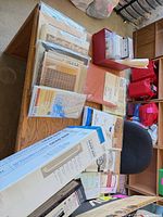 Overall view of packaged shower liners, curtain panels and boxed grab bars on table