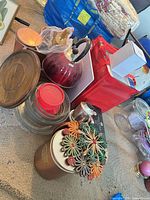 Group shot showing red kettle, glass bowls, copper tins and decorative flower tin