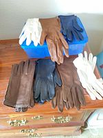Overview of seven glove pairs on storage box and dresser
