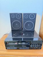Front view of stereo unit with both speakers stacked on turntable cover