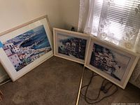 All three framed prints leaning against wall showing sizes and frames