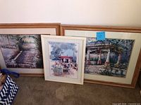 Three framed prints leaning against wall