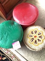 Top view of three round ottomans showing colors, materials, wear
