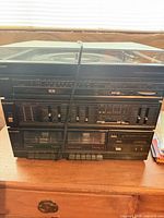 Front view of Sharp SG-55 stereo system showing turntable lid, control panel, dual cassette decks