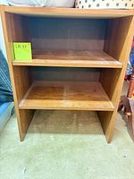 Front view of small brown laminate bookcase showing two fixed shelves