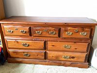 Front view showing all seven drawers and brass handles