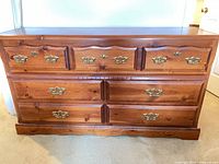 Front view of medium brown 7-drawer dresser showing hardware and overall condition