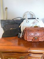 Group shot of four handbags on dresser