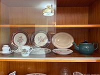 Cabinet view showing plates, teacups, and sugar bowl