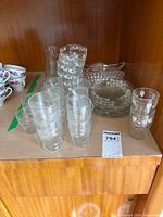 Group of etched tumblers, etched plates, and stack on shelf