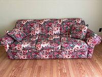 Front view of floral sofa with cushions and pillows