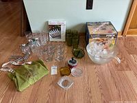 Full lot showing punch bowl set, steak knife box, assorted drinkware, bottles, ashtrays, metal tools, apron