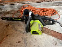 Poulan ES350 chainsaw, bar sheath, and extension cord on floor