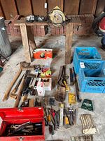 Entire lot laid out showing circular saw, toolbox, hand tools, crates