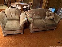 Loveseat and armchair set side by side on carpeted floor