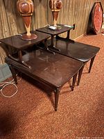 Pair of two-tier dark wood end tables side by side