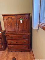 Full view of wooden armoire showing doors and drawers