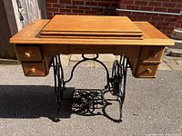 Front view of refinished oak treadle table on iron base