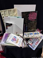 Group shot showing palette tray, colouring book, paint tubes, canvases, pads, brushes, paint pots