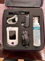 Kit inside case showing device, probe, adapter, strap, gel