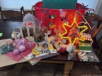 Overall lot on table showing tote, candelabra, ornaments, lights, reindeer, books