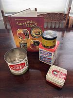 Group shot showing all tins and book