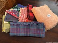 Stack of assorted textiles showing airline blanket in foreground